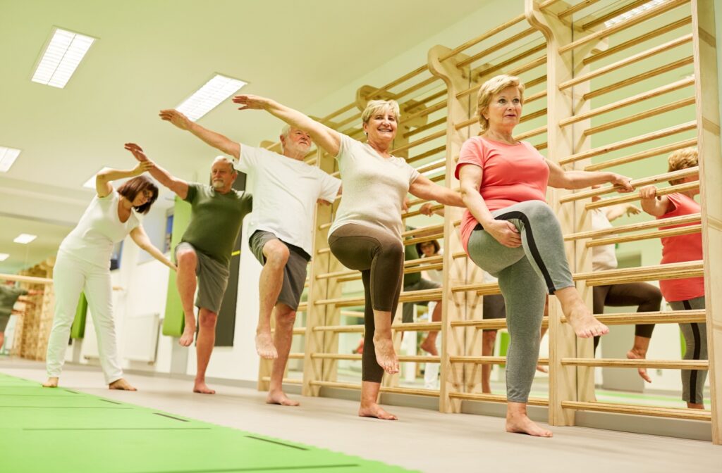 A physiotherapist leads seniors through a group balance class offered by their senior living community to reduce fall risk