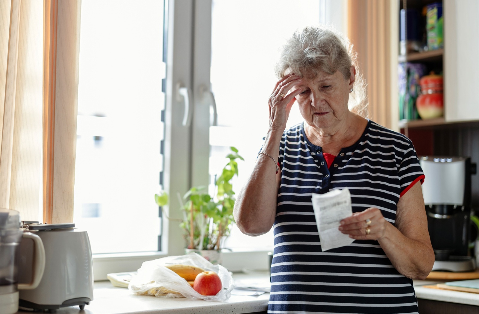 A senior looks at a receipt and struggles to remember