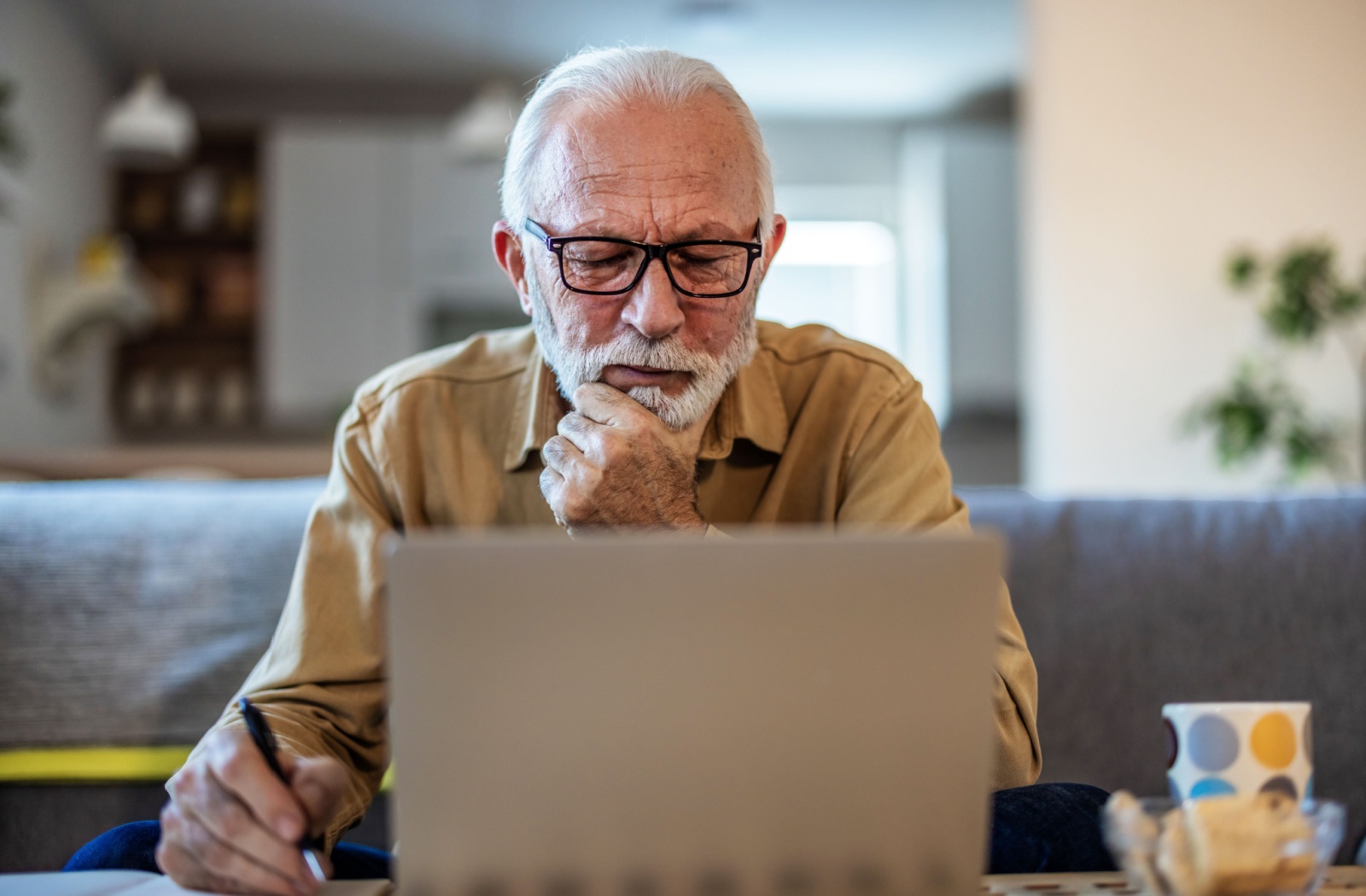 A senior sits at a laptop, browsing through emails and deleting those that look suspicious.