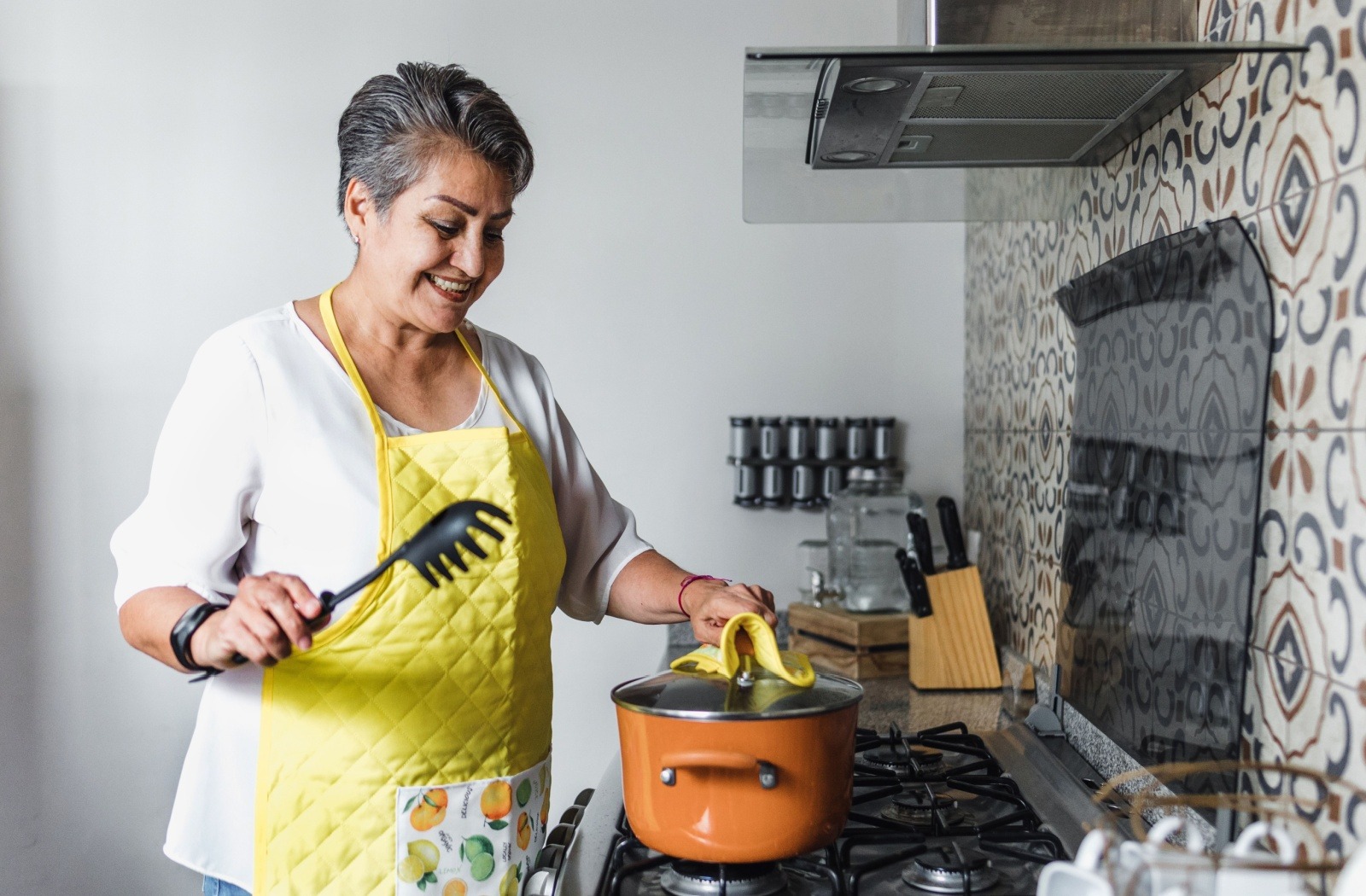 A senior cooking a healthy meal in their senior living apartment kitchen