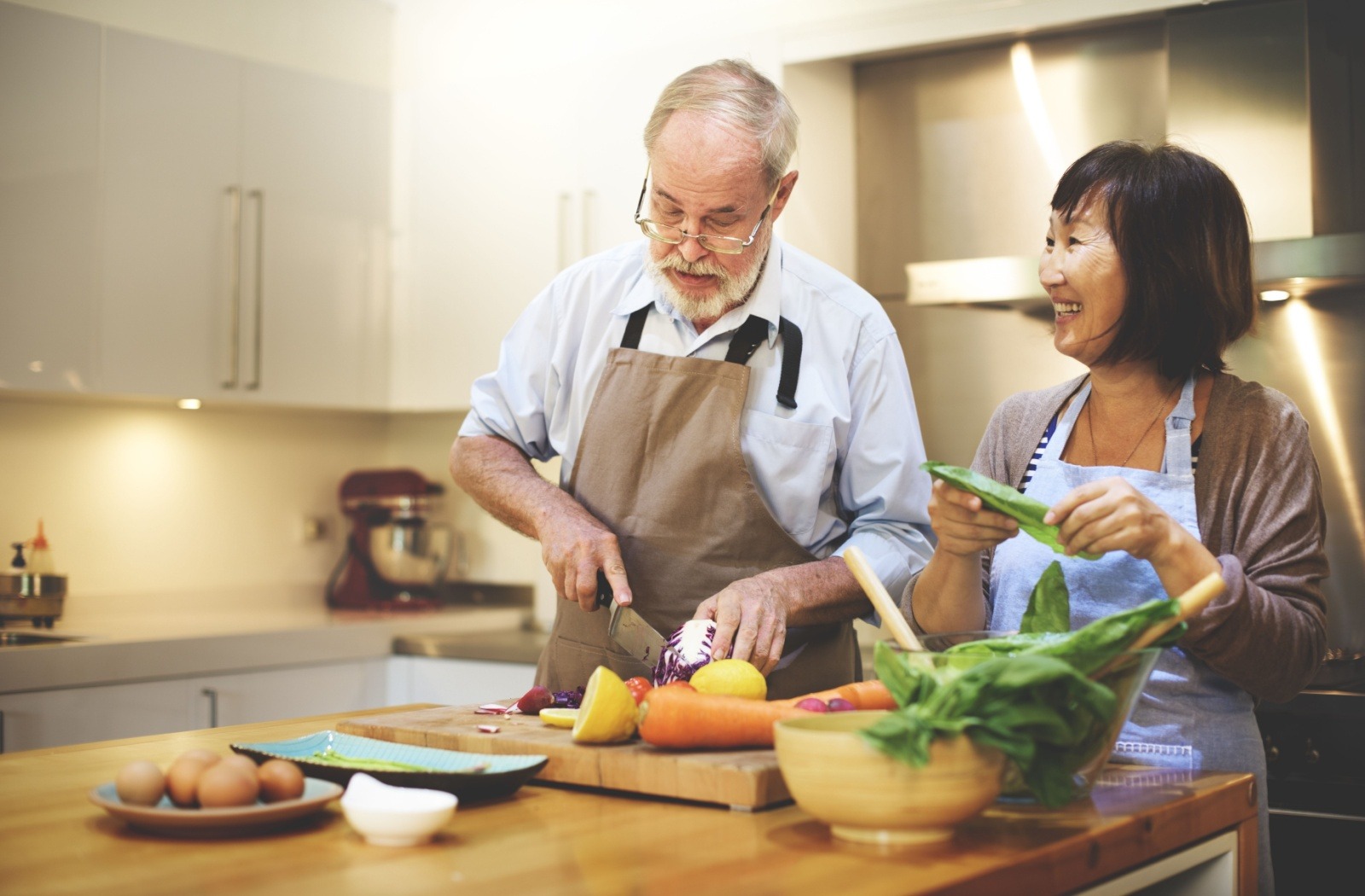 Two seniors prepare a healthy meal together.
