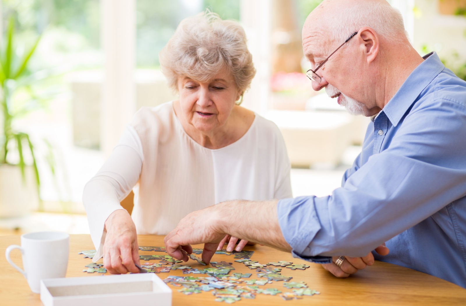 Two seniors complete a puzzle together